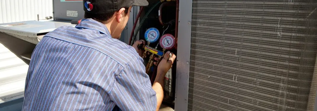 HVAC technician servicing a condenser unit in Mount Zion
