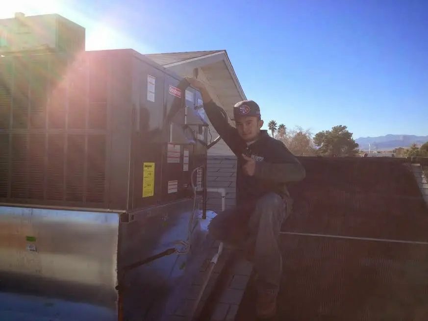 HVAC technician performing Heat Pump Repair on a rooftop unit in Mount Zion